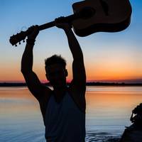 FREEPIK-cookie_studio_silhouette-young-handsome-man-holding-guitar-seaside-sunrise.jpg